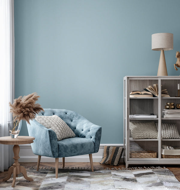 Corner of a stylish living room with walls decorated in Ocean Breeze, a dusty blue paint from Zhoosh.