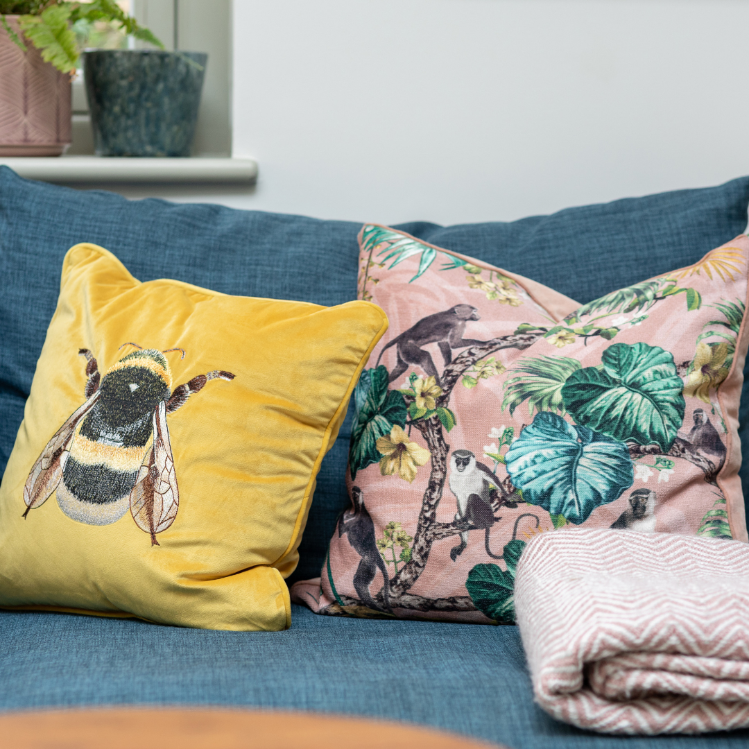 Cosy yellow and pink cushions on a blue sofa