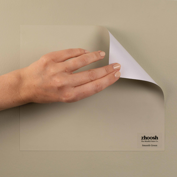 A hand peels a Smooth Green paint patch from the wall