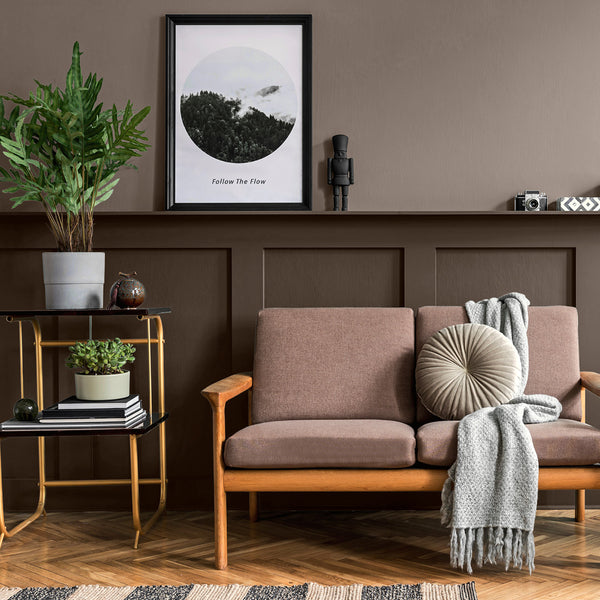 A reception room decorated with After the Storm, one of Zhoosh Paint's darkest greys, accompanied by vibrant plants and minimalist furniture.