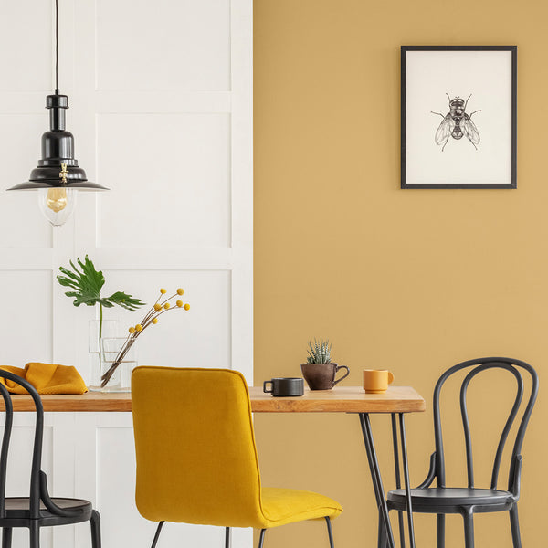 Dining room with walls decorated in Beehive golden yellow paint colour.