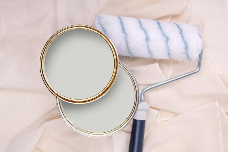 Tins of Mellow Grey paint with a paint roller