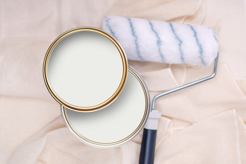 Tins of Mellow White paint with a paint roller