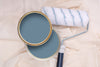 Tins of Reggae Blue paint with a paint roller