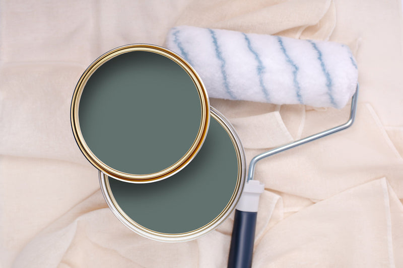 Tins of Soulful Green paint with a paint roller
