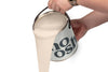 A person pours Country Pink paint from a tin